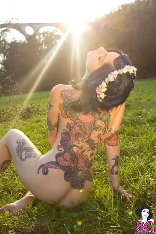 Татуированная  красотка позирует голышом перед камерой на природе 14 фото
